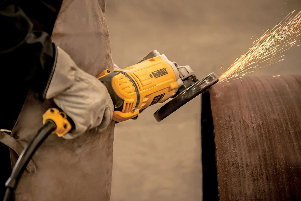 Pulidora DEWALT DWE4577-B3 desbastando un tubo metálico en taller