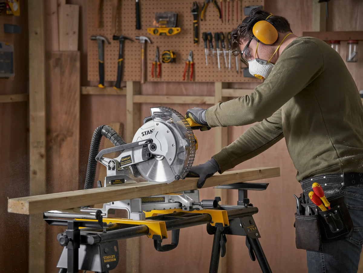 Carpintero cortando una tabla con la sierra ingleteadora STANLEY SM161-B3