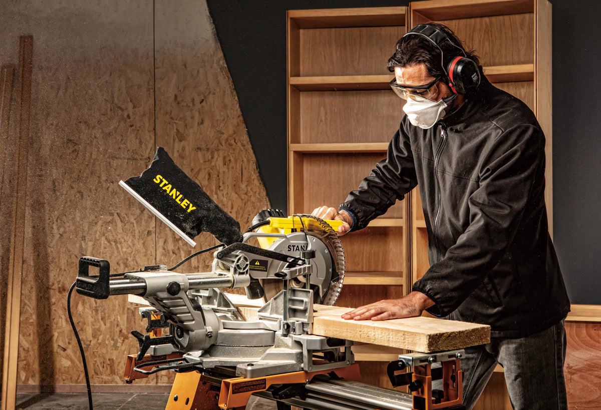 Carpintero cortando una pieza de madera con la ingleteadora telescópica STANLEY SM181-B3